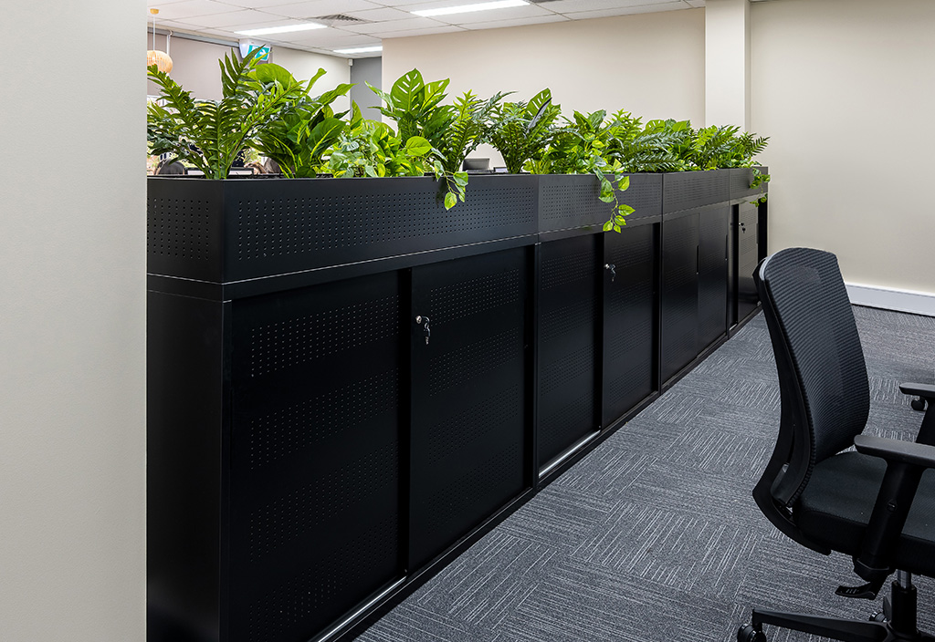 Close up detail of storage unit with planter box on top as a room divider in office