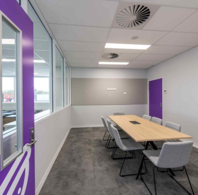 Office chairs around meeting table in enclosed office space